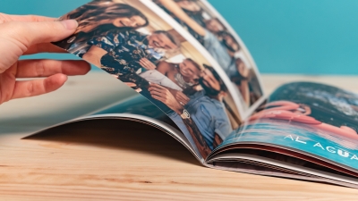 Tapas de Fotorevista Fotoprix. Foto en uso pasando las hojas y mostrando el grosor y flexibilidad de las mismas. La revista es ideal para regalar tus momentos más divertidos.