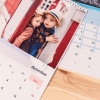 Varios calendarios personalizados con fotos de tamaño A4 de Fotoprix. Foto de los cuatro calendarios decorando un mural de madera colocado en la pared.
