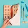 Imprenta de Fotoprix, foto en uso de una mano abriendo un bloc de notas mostrando el contenido de las páginas con cuadrícula para escribir.