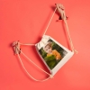 Regalos de Fotoprix, foto en uso sujetando las asas de cuerda de una mochila de lino. Presume de foto especial a cada sitio que vayas. También es un regalo perfecto.