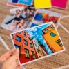 Imprimir copias Fotoprix, foto detalle de una copia de tamaño 11x15 sujetándola con la mano, mientras el resto están decorando una mesa.