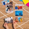 Imprimir copias Fotoprix, foto en uso sujetando una foto tamaño 11x15. Imprimir copias Fotoprix, foto en uso de varias copias de tamaño 11x15 y sujetando una de ellas mientras el resto están en una mesa.