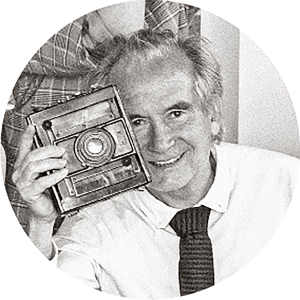 Foto estilo retro, con una cámara antigua en su mano, de Juan Mendizabal, propietario y CEO de Fotoprix.