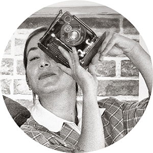 Foto estilo retro, con una cámara antigua en sus manos, de Maider, escaparatista de las tiendas Fotoprix.