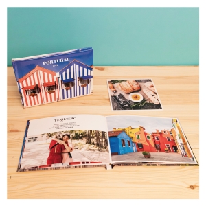 Álbumes Fotoprix. Foto de Fotolibro Plus 20x15 decorando una mesa de hogar. Álbum con apertura total apreciándose textos y fotografías.