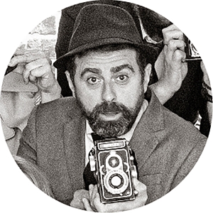 Foto estilo retro, con una cámara antigua en sus manos, de Ramón Barrantes, director comercial de Fotoprix.