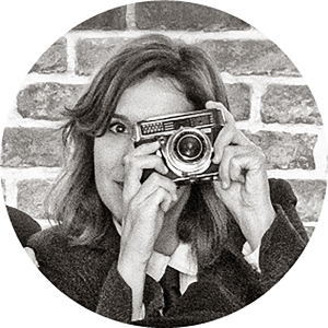 Foto estilo retro, con una cámara antigua en sus manos, de Elisa, diseñadora gráfica de Fotoprix.