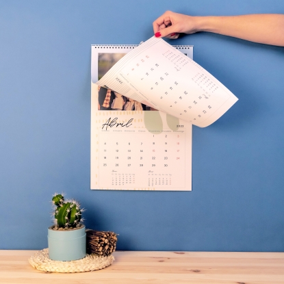 Detalles del calendario personalizado de Fotoprix: Foto en uso del calendario pasando página del mes de Marzo mientras está colgado en la pared.