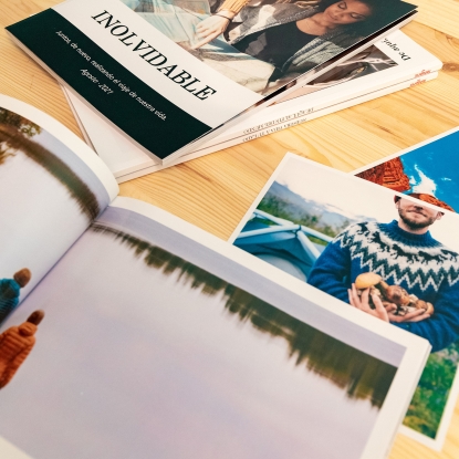 Productos de Fotoprix, foto de un Álbum Fotolibro rústico abierto completamente y colocado en una mesa junto a otros cerrados a modo decorativo.