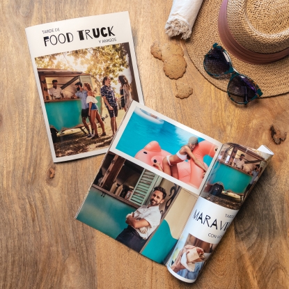 Productos de Fotoprix, foto de Álbum Fotorevista doblada y colocada en una mesa de madera a modo decorativo y alado otra cerrada.