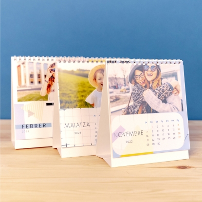 Detalles del calendario Fotoprix: Foto de tres calendarios de sobremesa colocados en una mesa y cada uno con texto en diferente idioma.