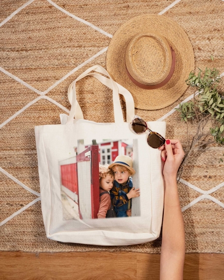 Regalos de Fotoprix, foto en uso de una de bolsa de lino para la playa. Imprime tu foto favorita a tamaño grande y enmárcala en un bolso personalizado con mucho estilo.