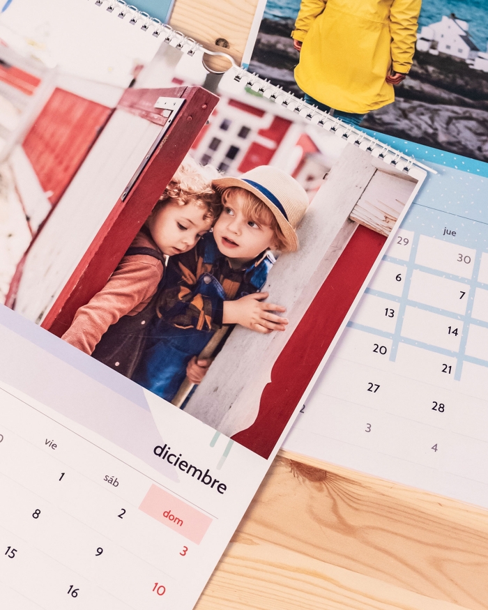 Varios calendarios personalizados con fotos de tamaño A4 de Fotoprix. Foto de los cuatro calendarios decorando un mural de madera colocado en la pared.