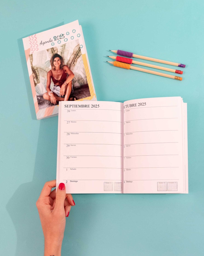Imprenta de Fotoprix, foto en uso de una mano sujetando una agenda de tapa blanda abierta en los meses de Septiembre y Octubre de  2022.