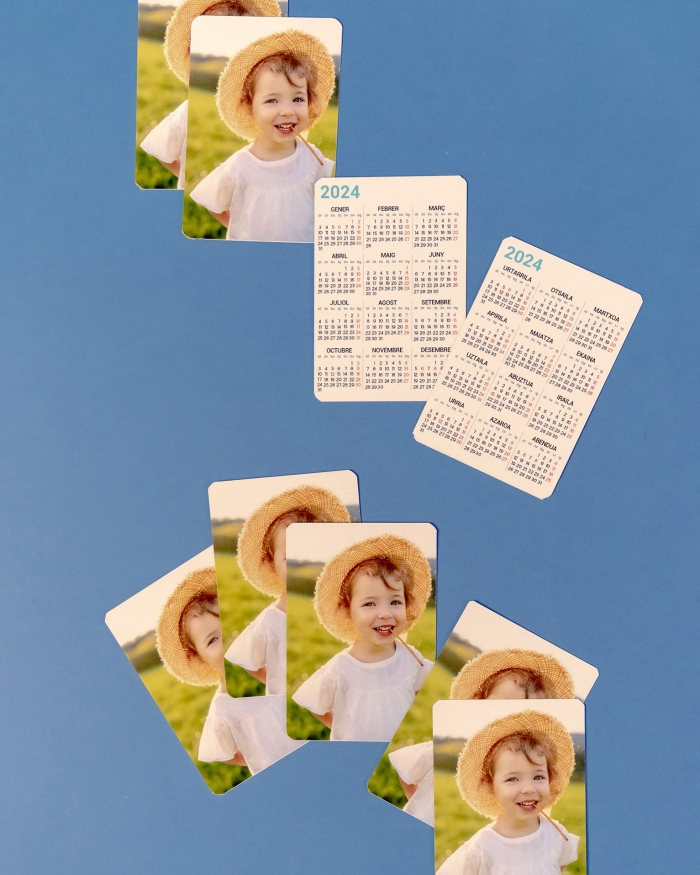 Productos Fotoprix. Calendario personalizado con fotos tamaño de cartera. Varios ejemplares y su parte delantera con calendario y su parte trasera con foto.