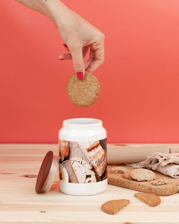 Regalos de Fotoprix. Foto en uso guardando una galleta en un bote de cocina personalizado. Conserva tus alimentos en un recipiente en el que observarás cada día tu foto favorita.