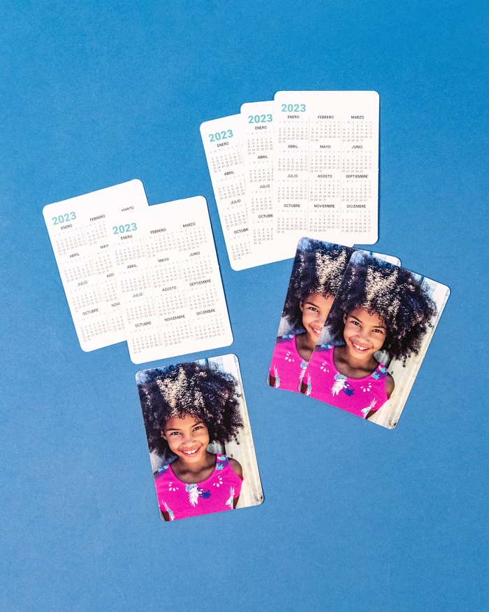 Calendario personalizado con fotos tamaño de cartera de Fotoprix. Foto en uso del calendario en la mano donde se ve la parte de alante y de atrás.