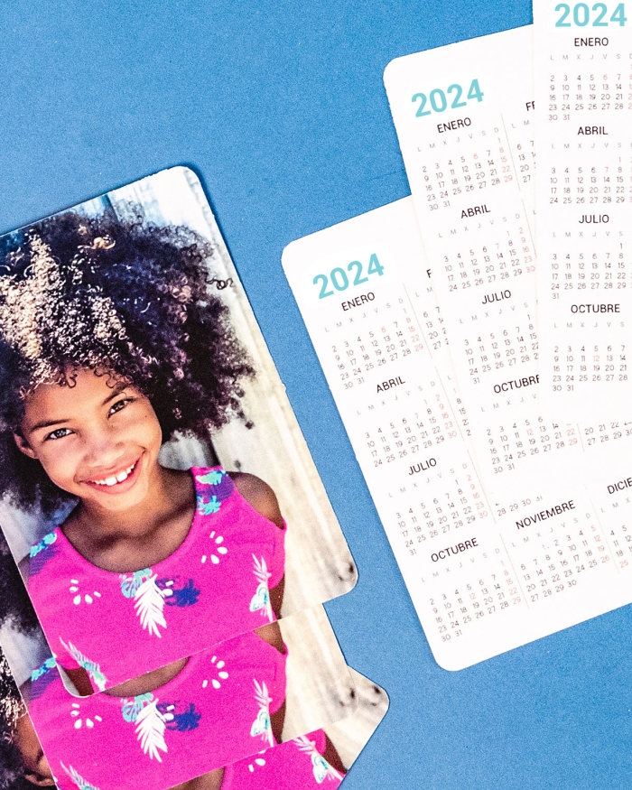 Calendario personalizado con fotos tamaño de cartera de Fotoprix. Varios ejemplares y su parte delantera con calendario y su parte trasera con foto.