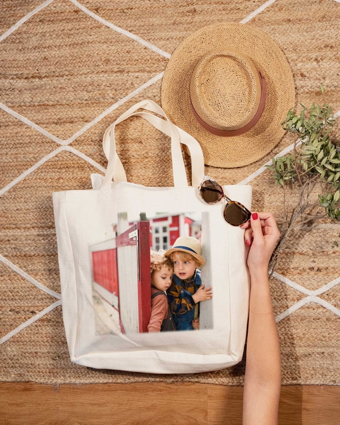Regalos de Fotoprix, foto en uso de una de bolsa de lino para la playa. Imprime tu foto favorita a tamaño grande y enmárcala en un bolso personalizado con mucho estilo.